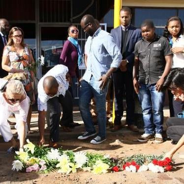 People lay flowers and pay their respects where Constitutional law expert Gilles Cistac was murdered on March 3, 2015, in Maputo, Mozambique. © 2015 Getty Images