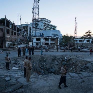 Afghan security personnel and residents stand near the crater left by a truck bomb attack in Kabul, May 31, 2017.