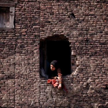 A woman watches the funeral of a civilian who, according to local media, was hit by a police vehicle during a protest after Friday prayers, in Srinagar, June 2, 2018. 