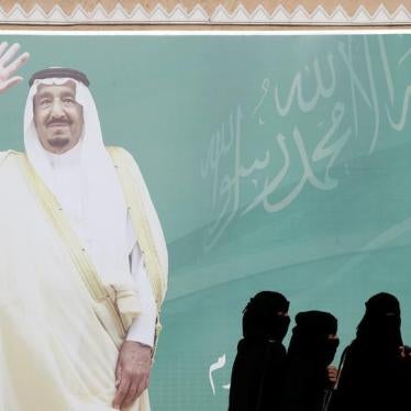 Women walk past a poster of Saudi Arabia's King Salman bin Abdulaziz Al Saud, Riyadh, Saudi Arabia, February 12, 2018. © 2018 Reuters