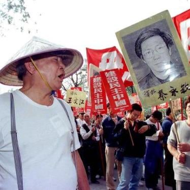 A Chinese Communist supporter (L) hurls insults to protesters as they began a march in Hong Kong January 1, calling for more democracy in China. The rally was first of a series of activities planned by pro-democracy activists in the territory to mark the 