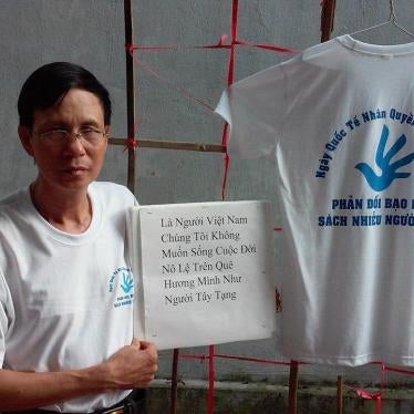 Nguyen Van Tuc carries a sign: Vietnamese do not want to live the slavery lives on our homeland like the Tibetans. The T-shirt reads: International Human Rights Day, December 10, 2014 – Protest against violence and harassment inflicted upon the people. 