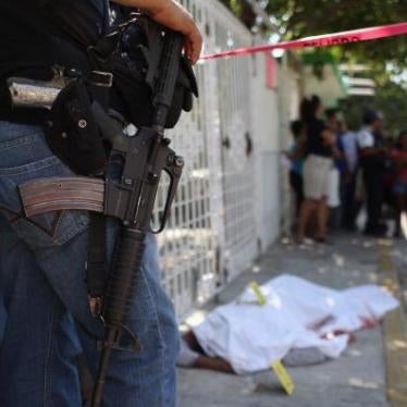 A policeman watches a covered body