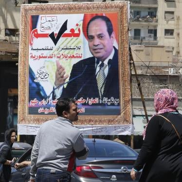 People walk past a banner supporting proposed amendments to the Egyptian constitution with a poster of Egyptian President Abdel Fattah al-Sisi  in Cairo, Egypt, Tuesday, April 16, 2019. © 2019 AP Images/Amr Nabil