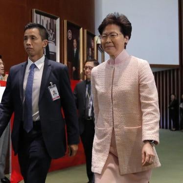 FILE - In this May 22, 2019, file photo, Hong Kong Chief Executive Carrie Lam, center, arrives for a meeting at the Legislative Council as the pro-democracy lawmakers chant placard and banner against the new extradition law in Hong Kong. Hong Kong's gover