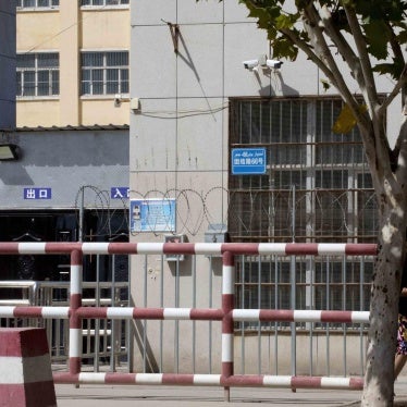 The entrance to the No. 4 High School with a sign that reads "Entering school grounds, please speak Mandarin," left, in Peyzawat, Xinjiang region. © 2018 AP Photo/Ng Han Guan