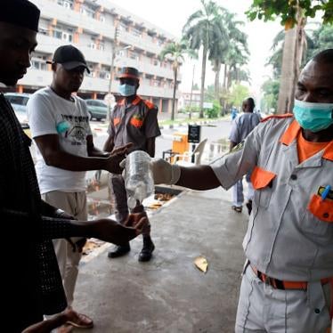 A securityman administers sanitiser to a visitor to a state hospital in Lagos, on February 28, 2020. 