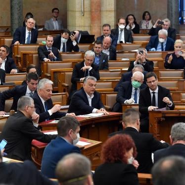 Hungarian Prime Minister Viktor Orban, center, his deputy Zsolt Semjen and other government members and MPs of the governing Fidesz party vote on a draft law concerning extraordinary measures during the plenary session of Parliament in Budapest, Hungary, 