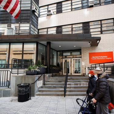 Pedestrians wearing masks walk by New York Presbyterian Lower Manhattan Hospital in New York, Monday, March 16, 2020.