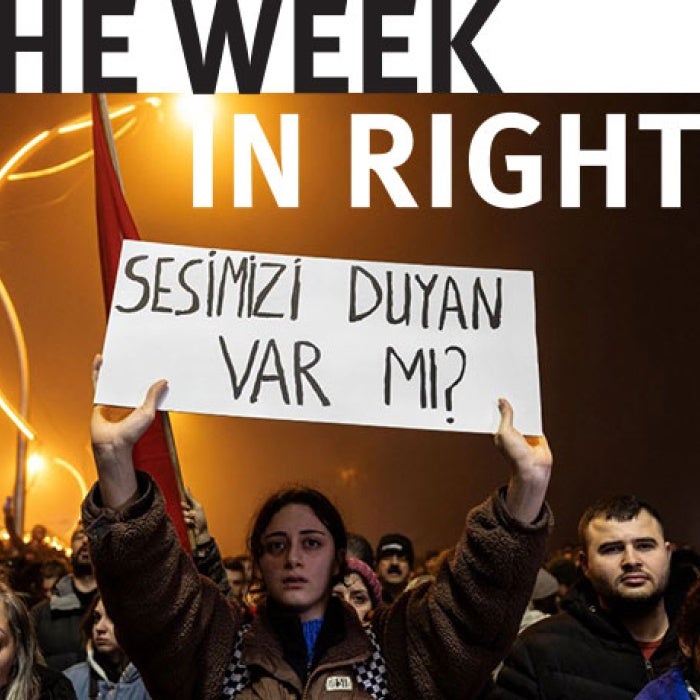 Protesters gather and display signs. 