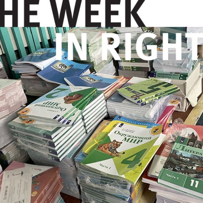 Piles of books sit together on a desk. 