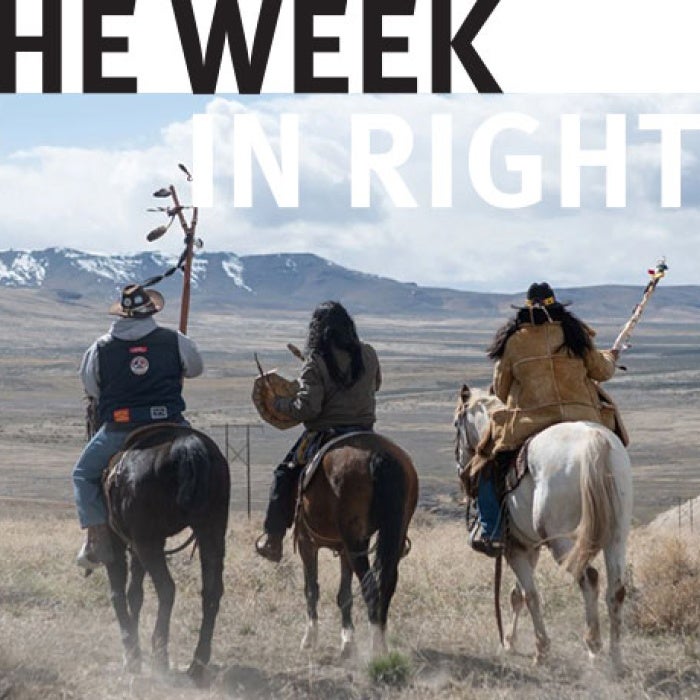 Three individuals ride horses in the desert. 