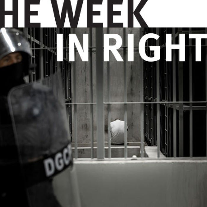 Police in protective gear stands near cell. 